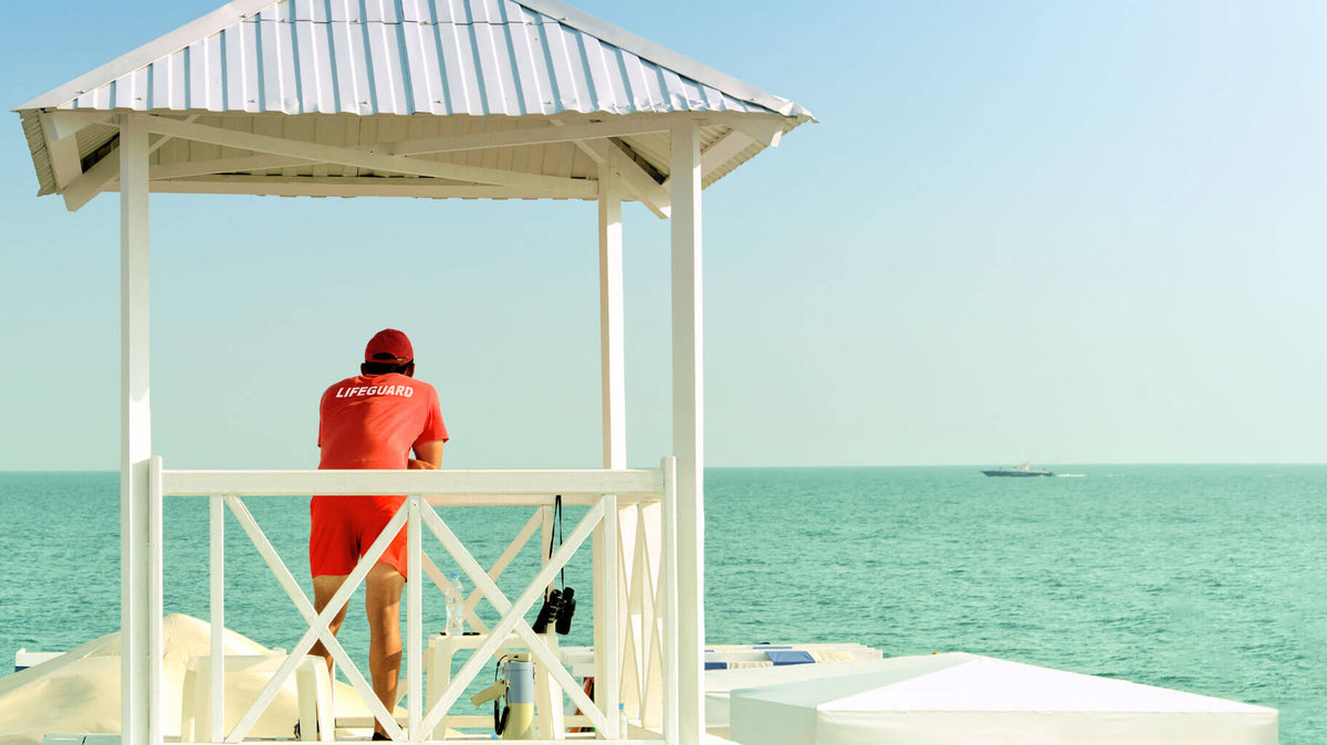 Lifeguard on a beach stand with a mineral sunscreen stripe across the nose