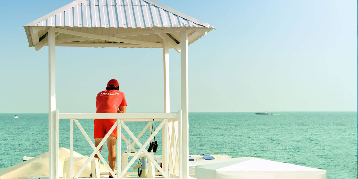 Lifeguard on a beach stand with a mineral sunscreen stripe across the nose
