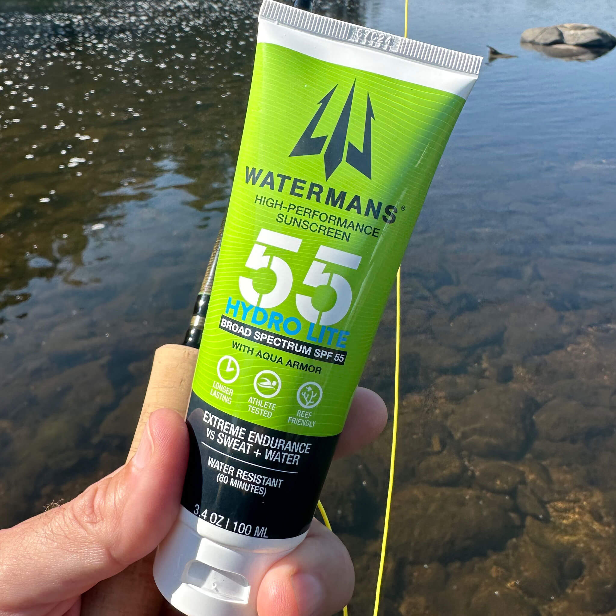 Athlete applying Watermans Hydro Lite SPF 55 sunscreen before outdoor activity